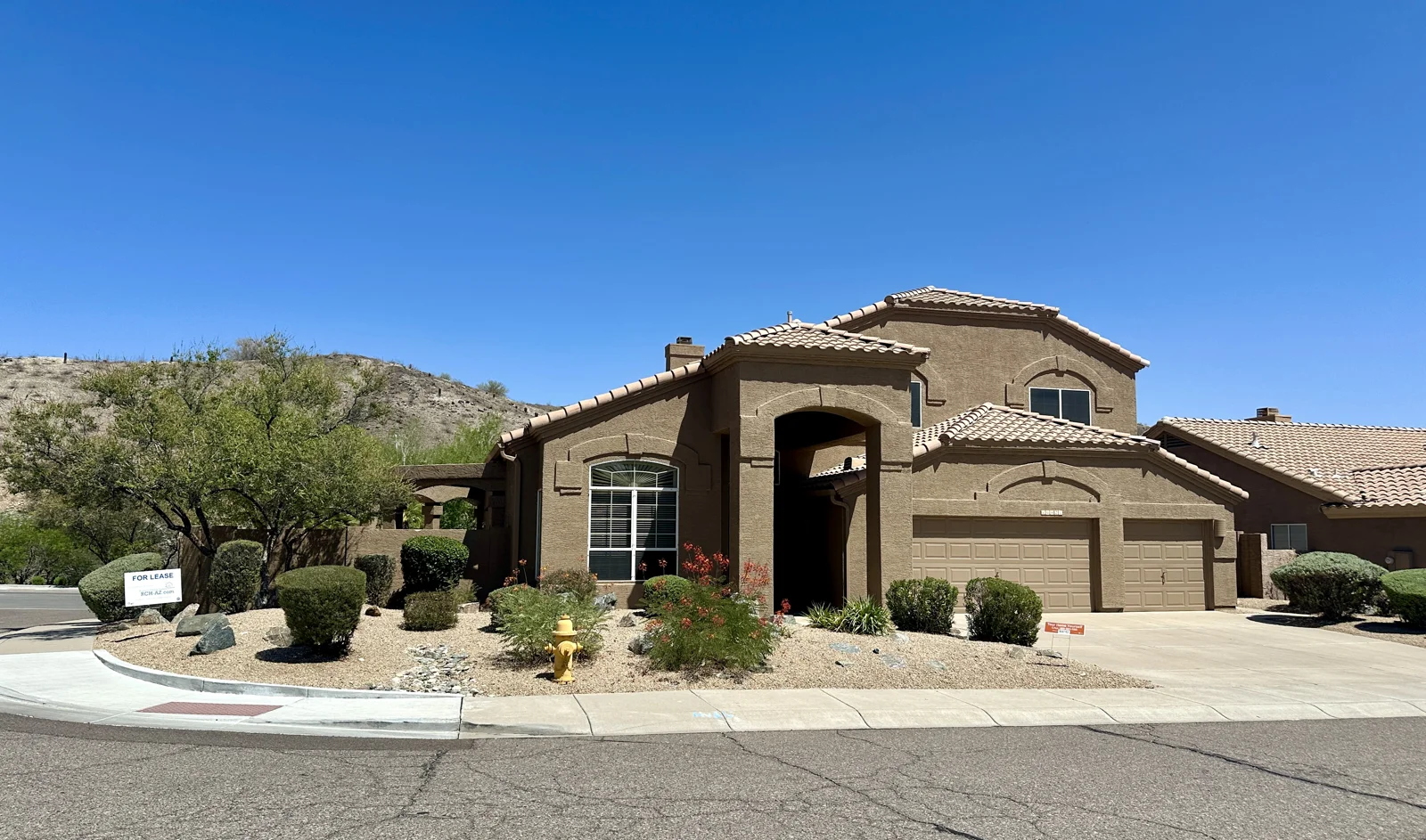 Arizona home with a tall shaded entry, tile roof and desert landscaping